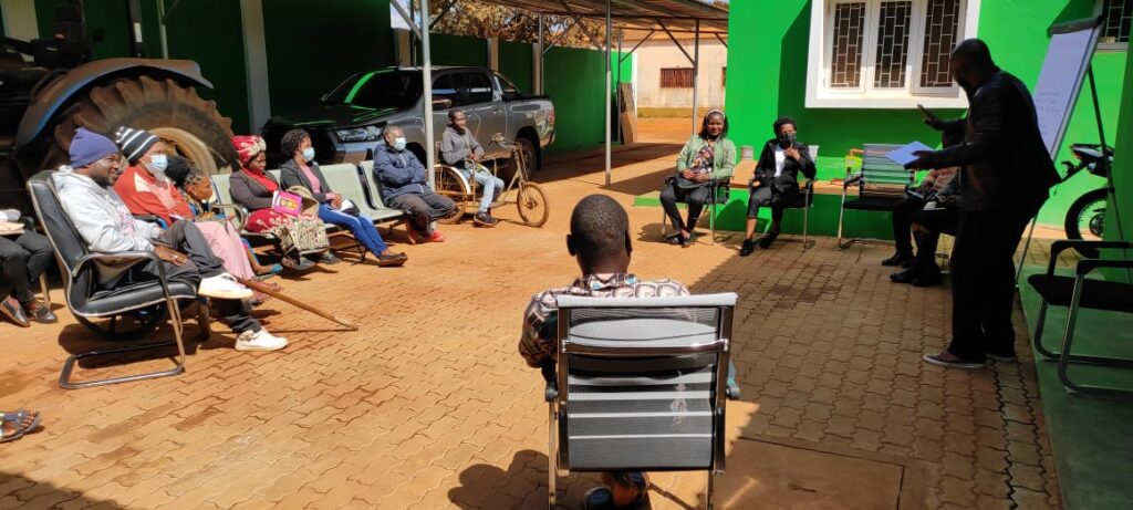 A group of young people with disabilities sitting outside participating in a training in Mozambique
