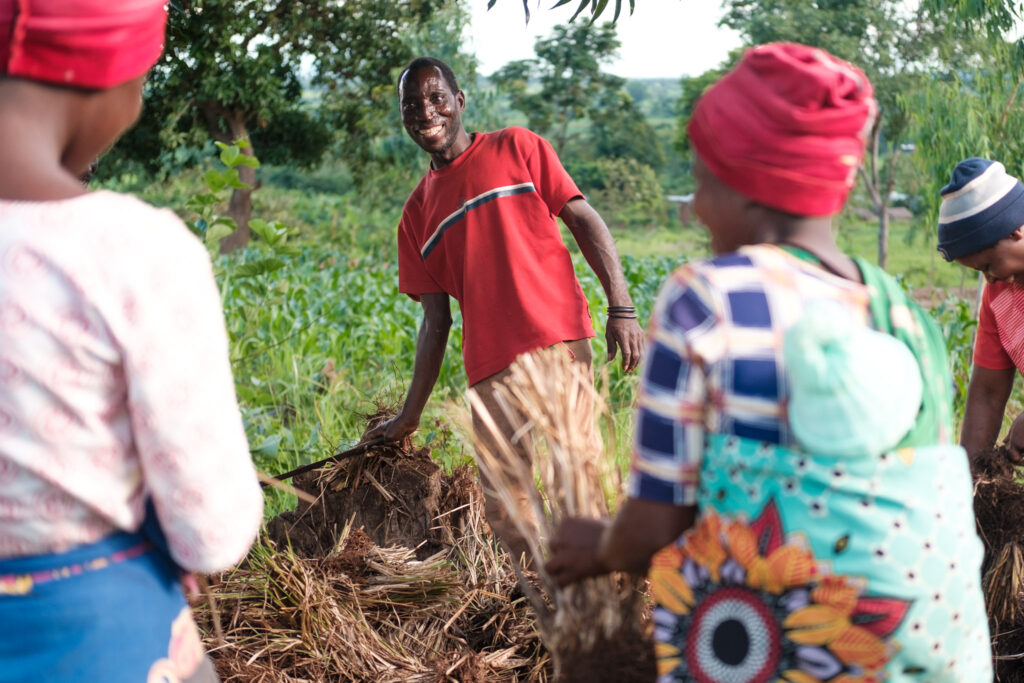 A man in a red shirt trains women working on a water catchment project in Malawi