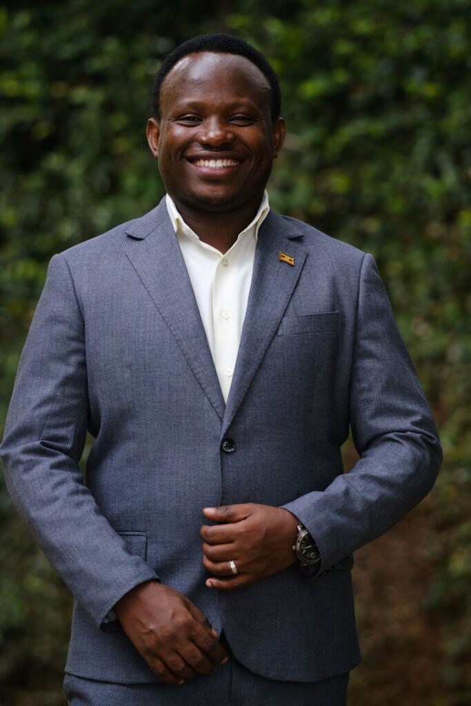 A portrait of a man in a suit standing and smiling