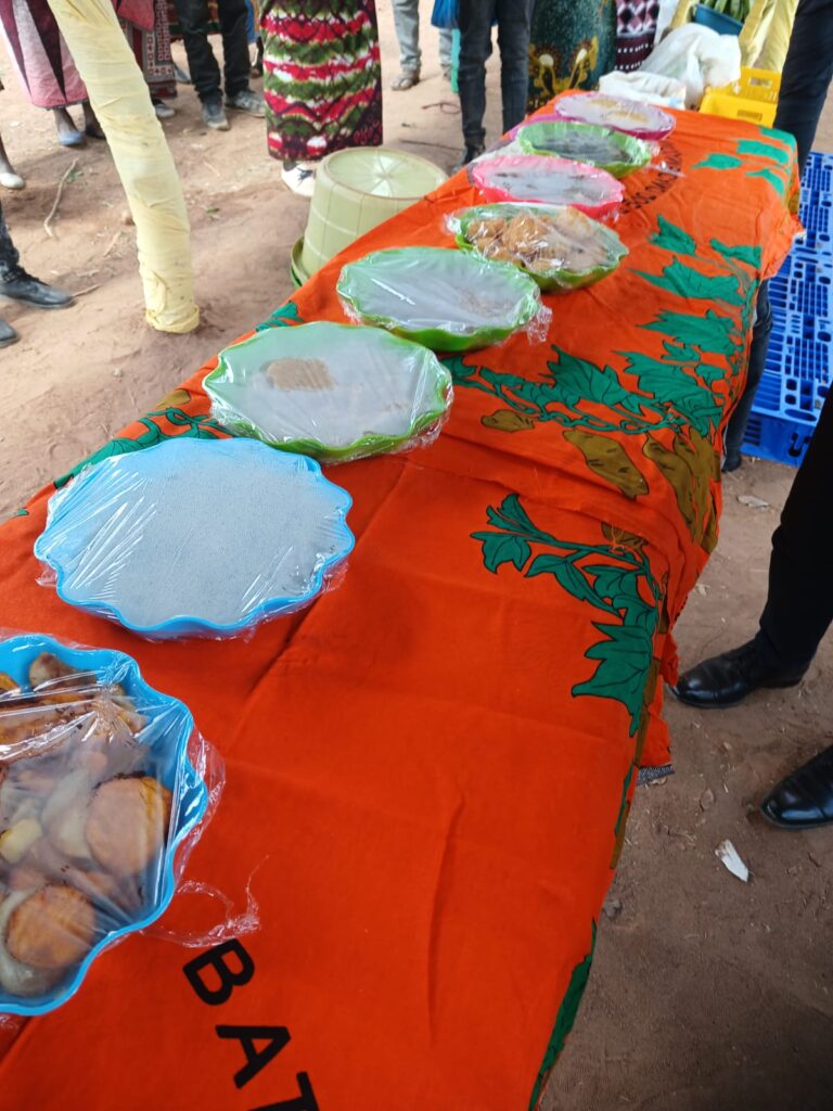 Bowls of farm grown food sit on a long table covered by an orange tablecloth