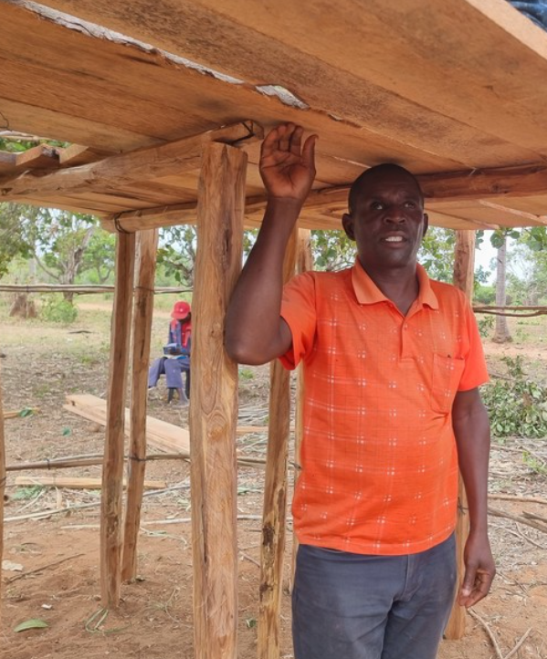 Man with visual impairment standing under a wooden construction.